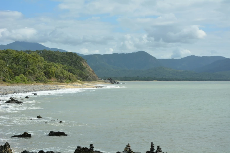 a large body of water next to a hill side