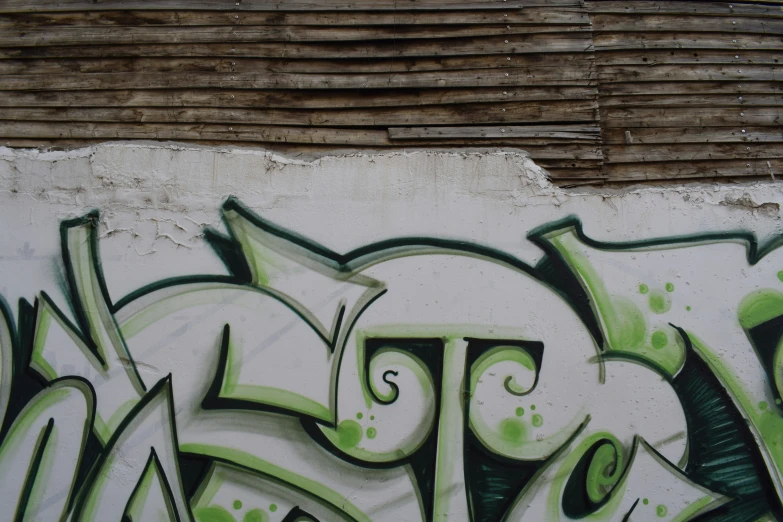 some green and black graffiti on a wall