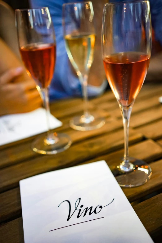 two glasses of wine and menu sitting on a table