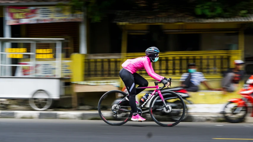 a person riding a bike in the road near a motorcycle