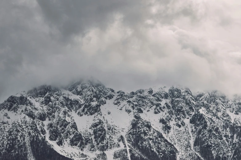 a bunch of snow covered mountains on a cloudy day