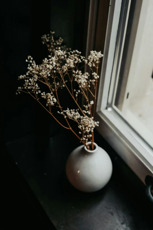 a small vase is on the windowsill