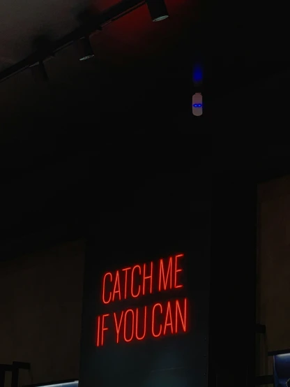 a neon sign reading catch me if you can