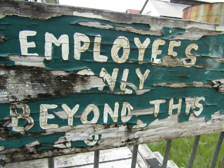 an old wooden sign that has been covered in graffiti