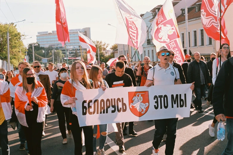 a crowd walking down a street carrying banners