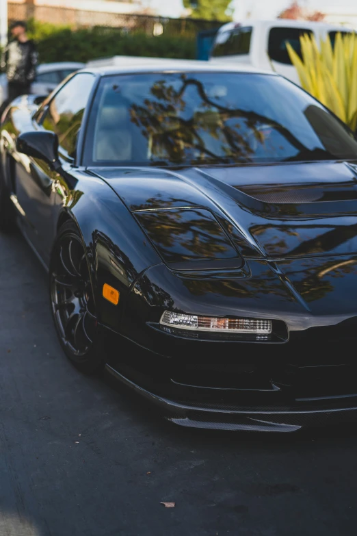 a black sports car on a street with other cars