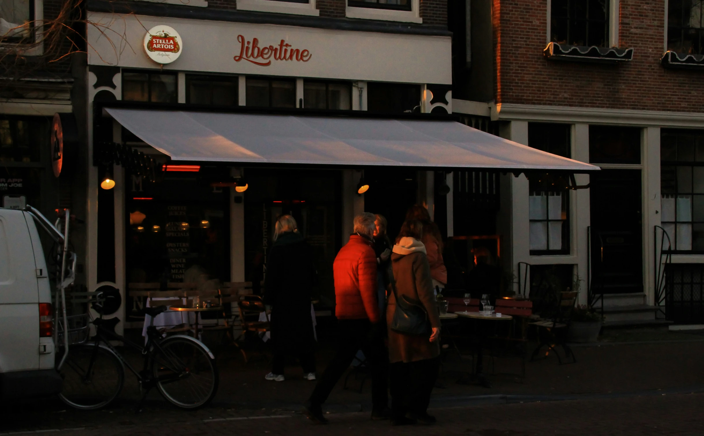 two people walking out of a restaurant at night