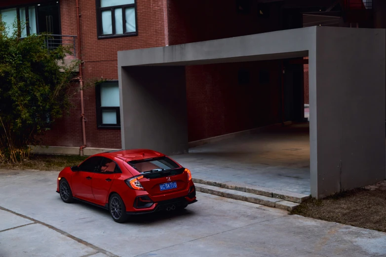 a red car in front of an empty parking space