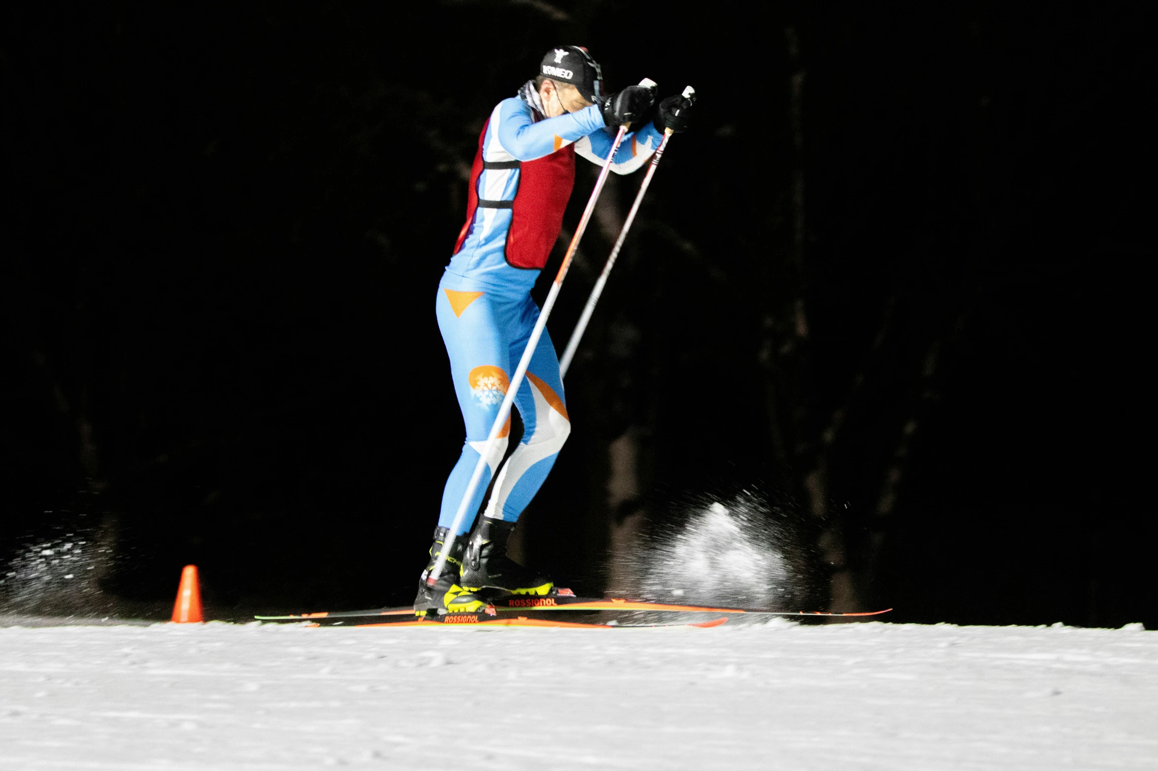 the skier is wearing colorful clothing and holding ski poles