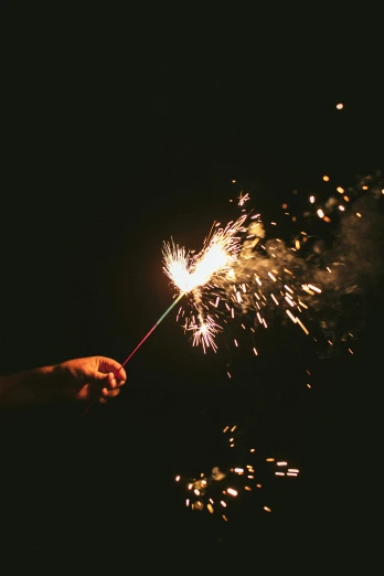 a person is lighting out sparklers on the ground