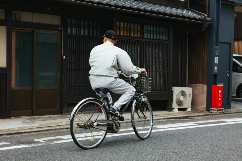 a man riding a bike down a street in front of a shop