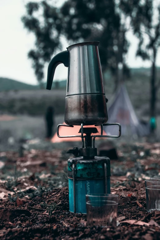 a metal coffee pot and kettle sit on top of an old gas stove