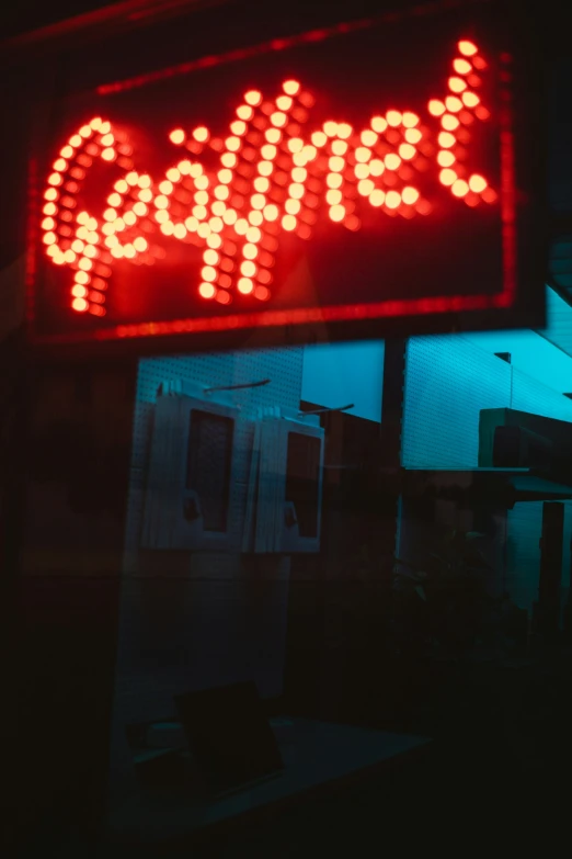 a sign is lit up in front of a dark building