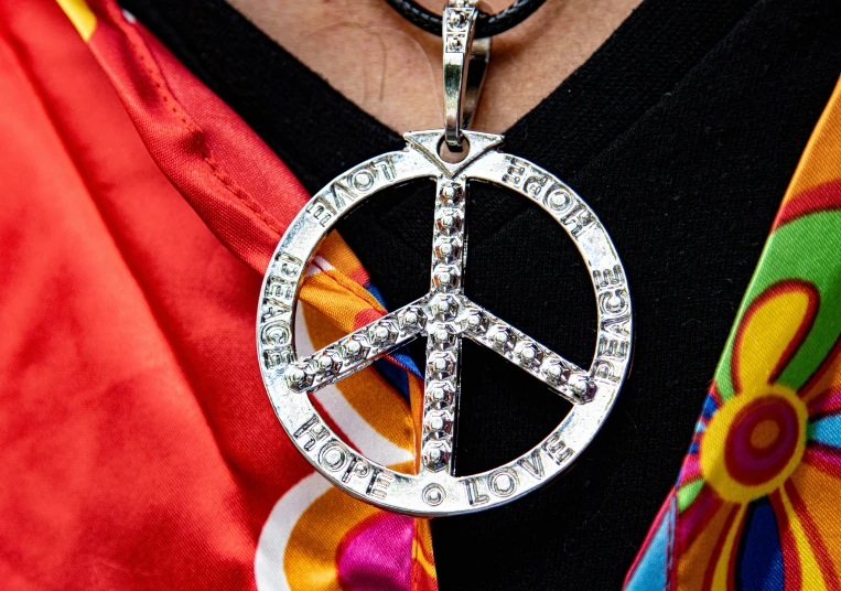 a person in a colorful scarf and necklace with a peace sign