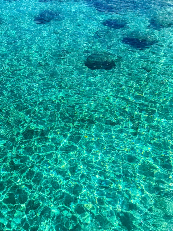 a plane flying over a crystal clear ocean