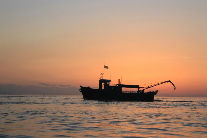 a ship is shown in the ocean during sunset