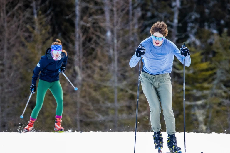 two people wearing skis in the snow