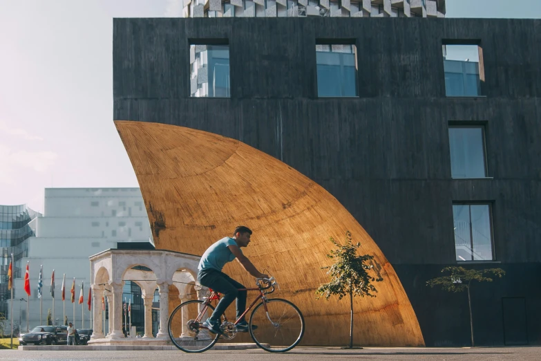 a man is riding his bike next to a large structure