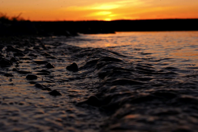 close up of a beach area as the sun sets