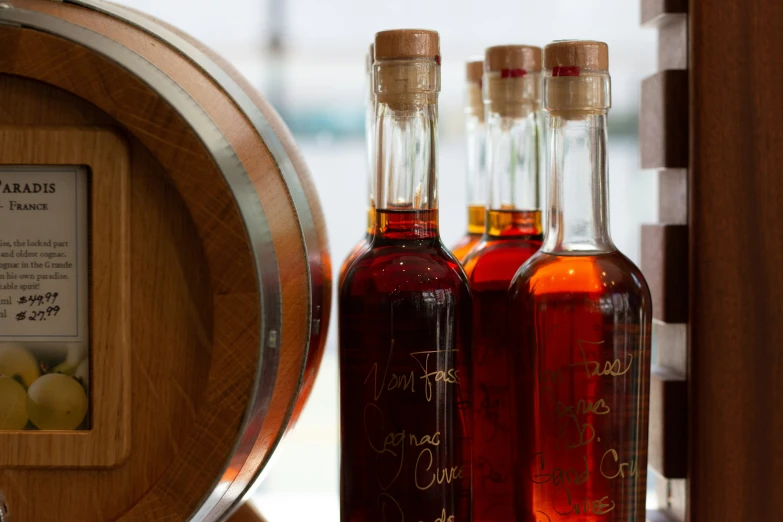 two glass bottles that are on the side of a barrel