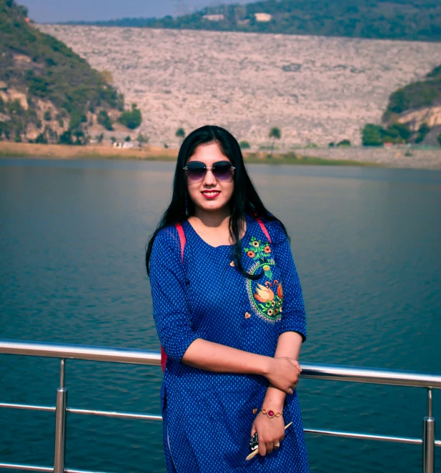 a woman is standing on a deck near the water