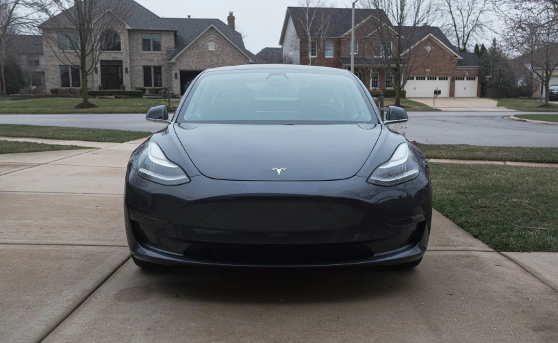 the front view of a black car on a driveway