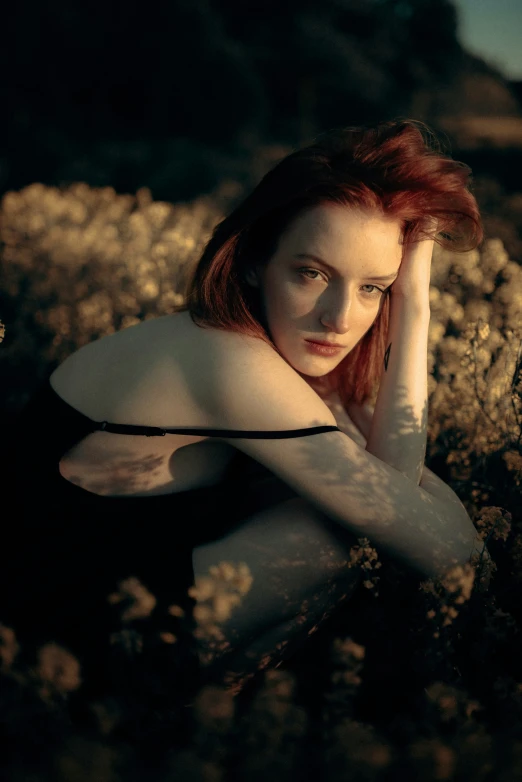 a girl sitting on the rocks posing for a picture