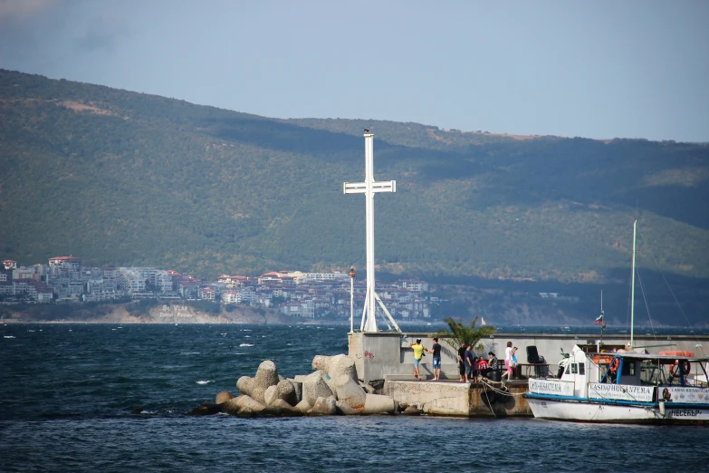 a cross atop a small white boat on the water