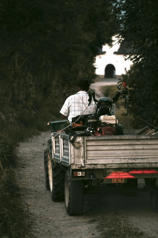 an older truck on the dirt with two men riding