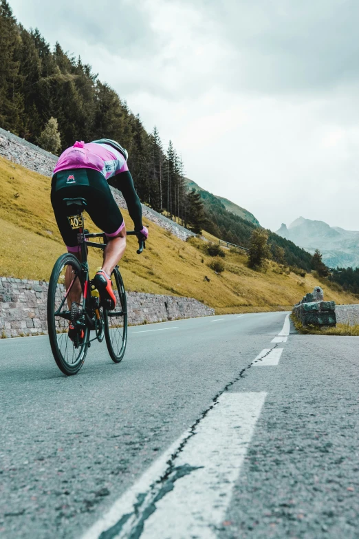 a cyclist in a pink helmet is on the road