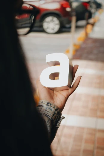 a woman holding out an image of a letter g in her hand