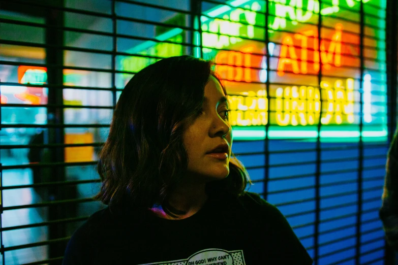 a woman standing in front of neon signs