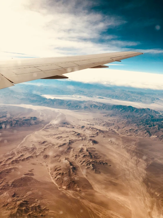 view out an airplane window, of the mountains and clouds