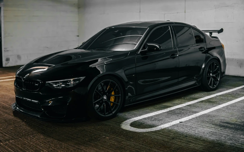 a black bmw car parked in a parking space