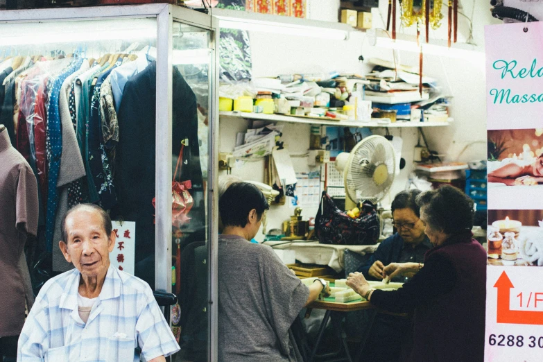 a po of an elderly man in front of a clothing shop