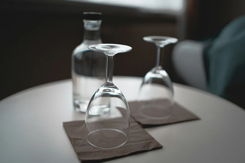 two wine glasses on top of napkins sitting on a table