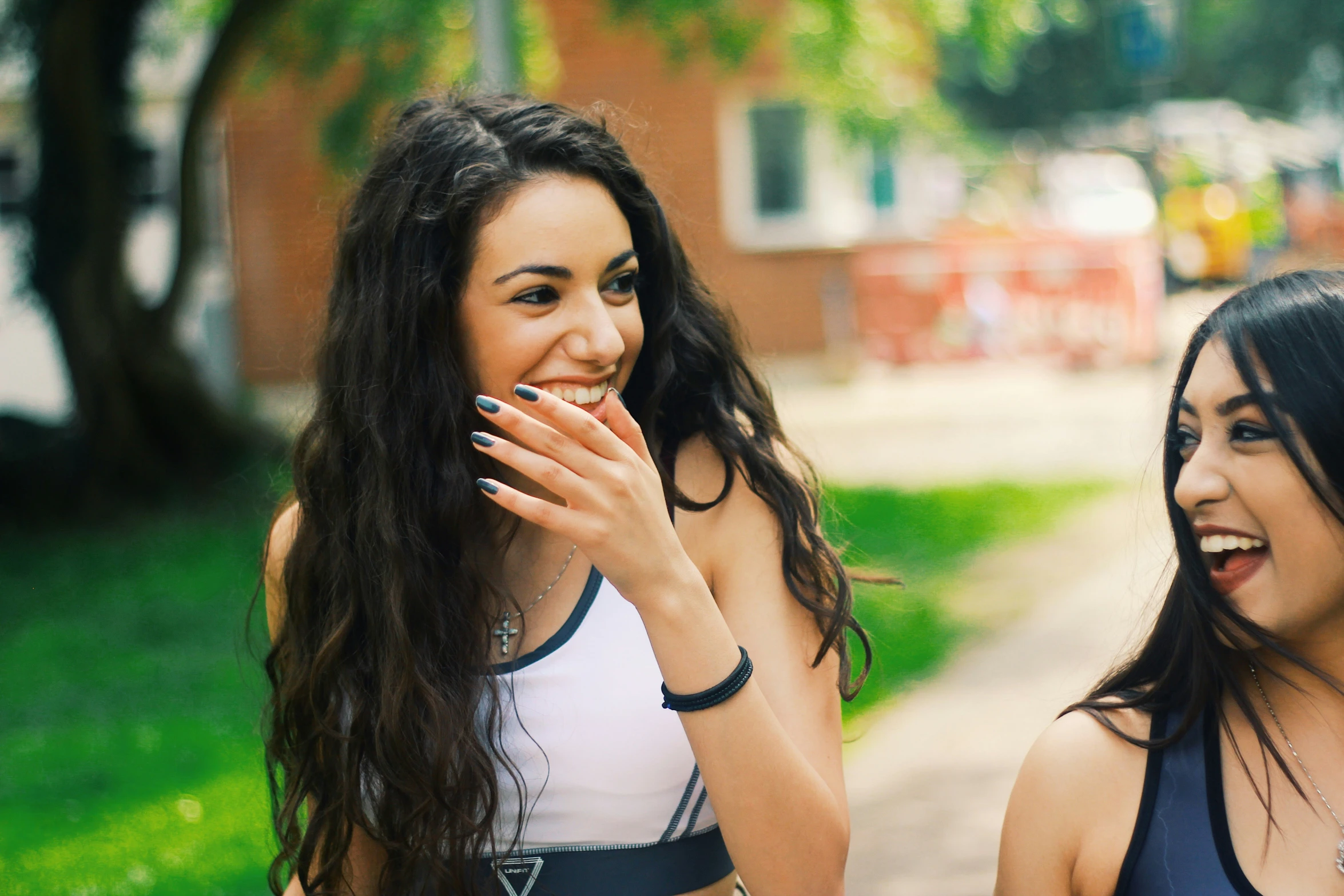 two women walking side by side laughing with each other