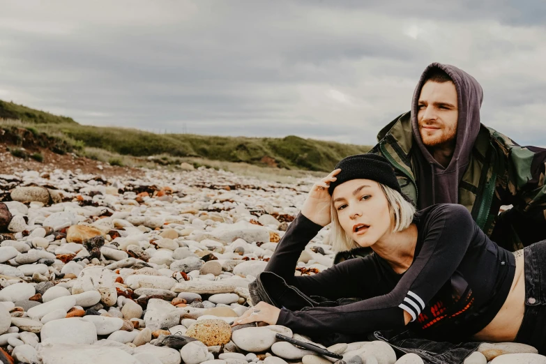 a man and woman laying on rocks posing for a pograph