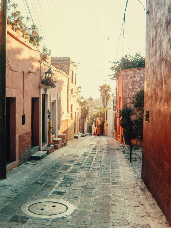 an empty street is shown with several people standing on either side