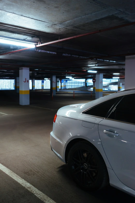 a car is parked in the dark of the parking garage