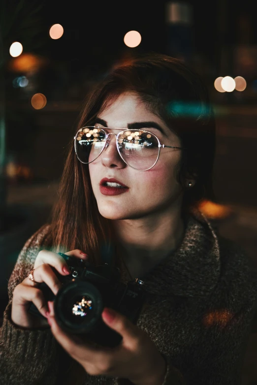 a woman in glasses taking a selfie with her camera