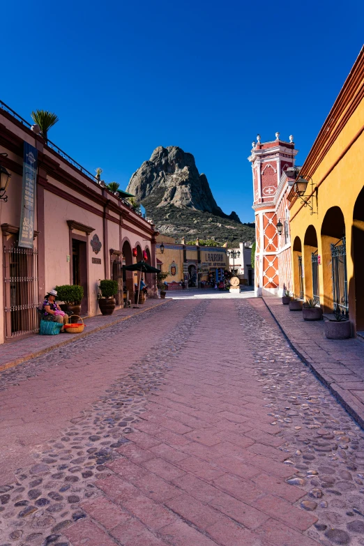 a city street lined with colorful buildings and flowers