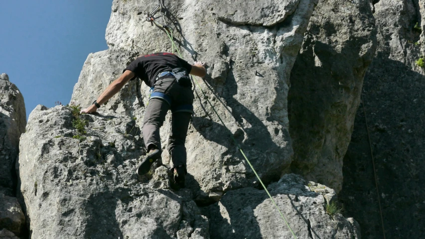 a man rock climbing in the mountains with rope
