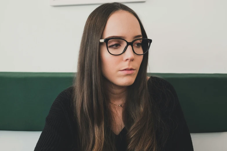 an attractive young woman wearing black glasses