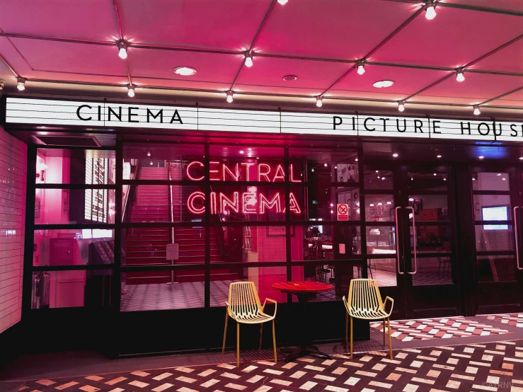 two yellow chairs sitting outside of a cinema