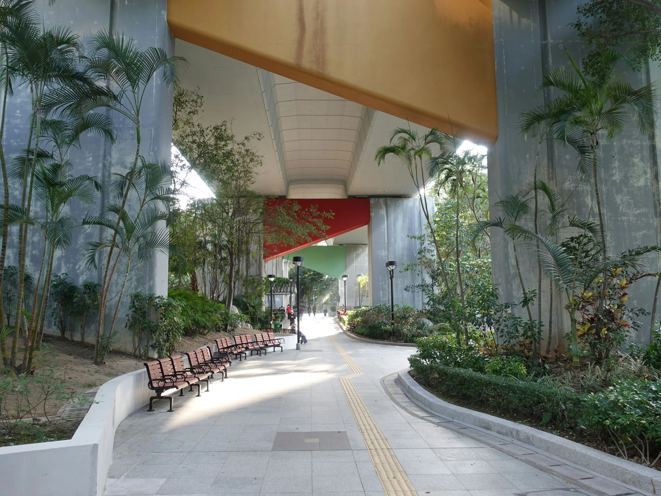 a long walkway is seen under the canopy of an overpass