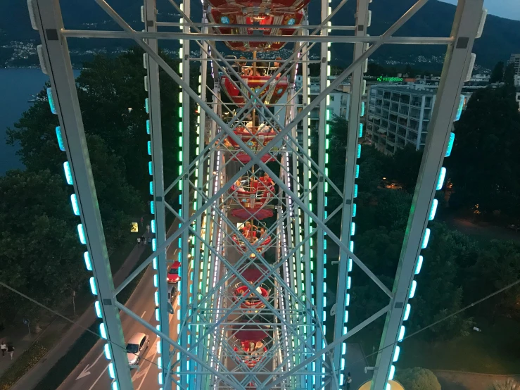 a ferris wheel near many cars and traffic at night