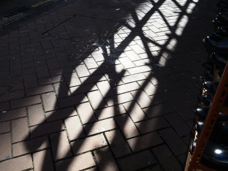 shadow of a skateboard sitting on top of a brick walkway