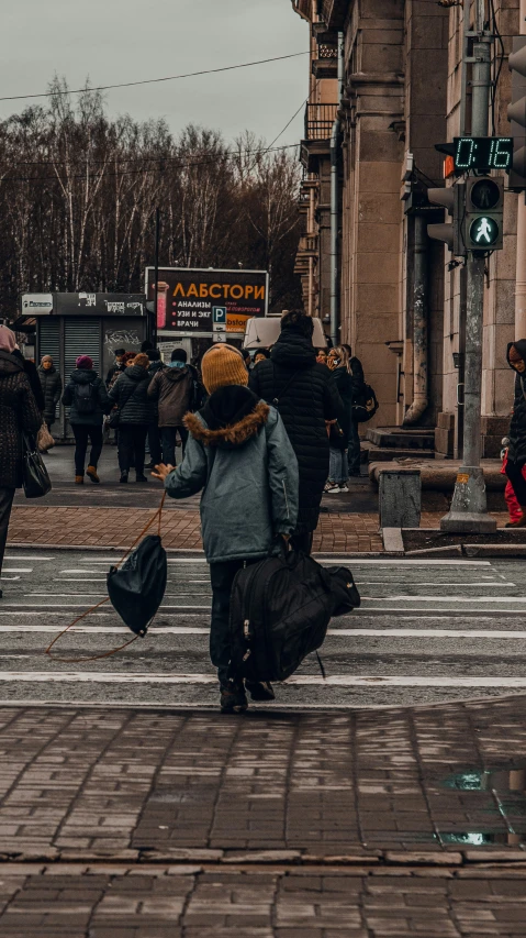 a person is walking across a street near a large group of people