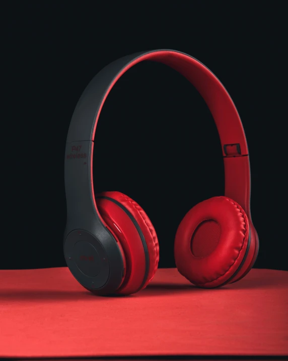 a red headphone sitting on top of a red surface